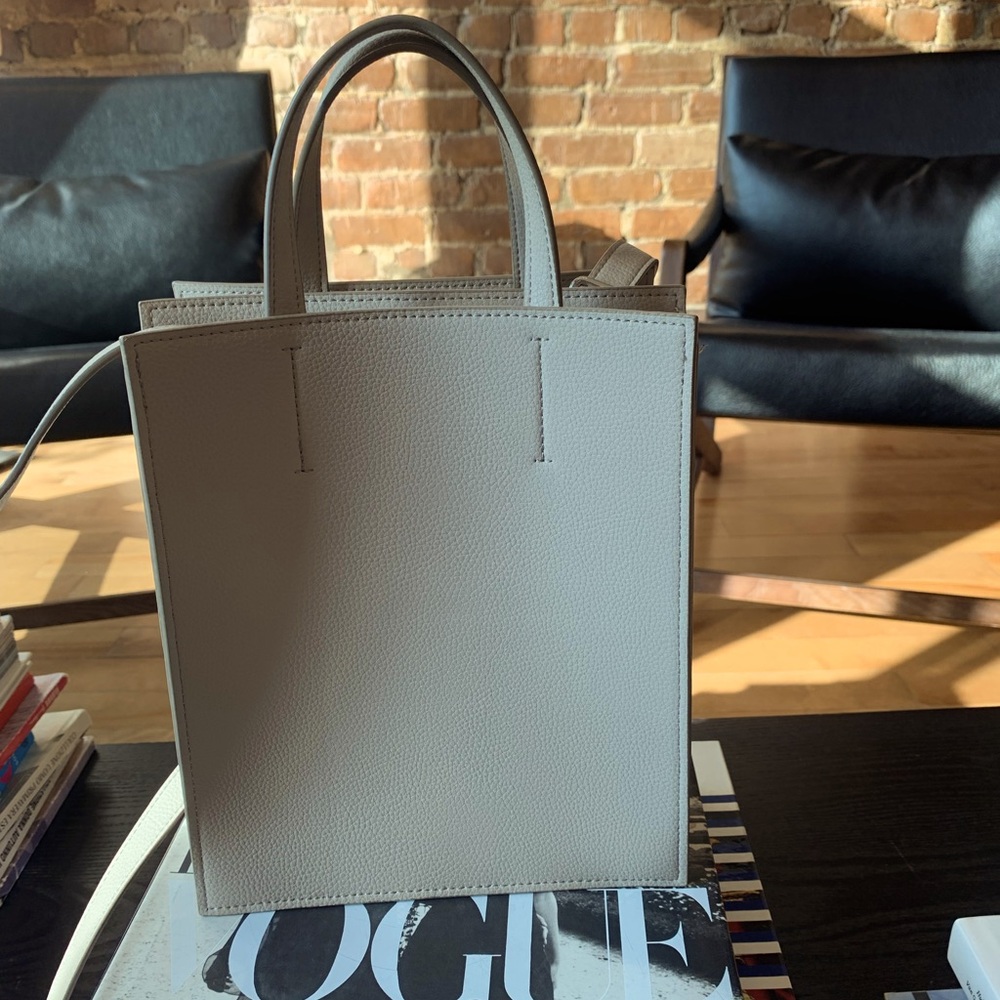 Modern Uniqlo pale grey bag with detachable shoulder strap.